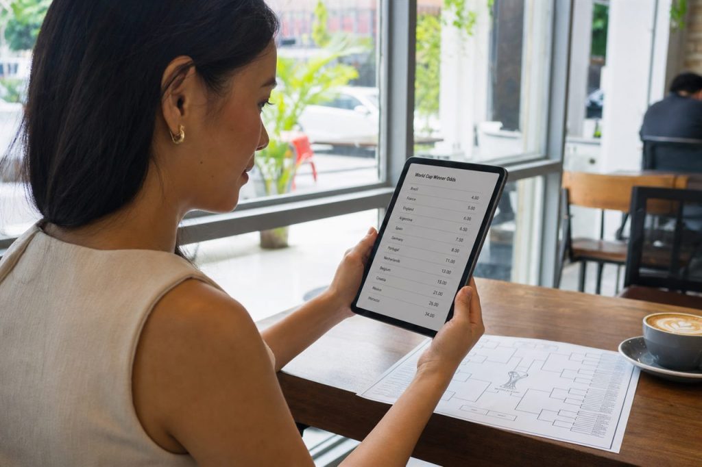 Filipina bettor reading World Cup 2026 outright odds on a tablet at a cafe